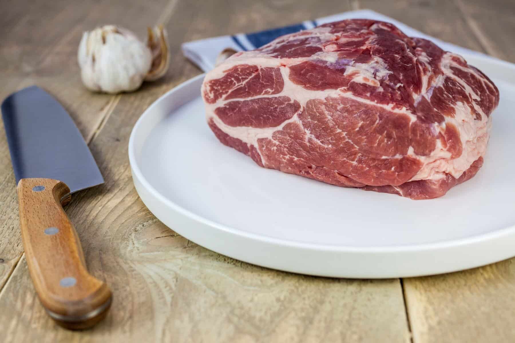 Schweinenacken auf Teller, roh, am Stück