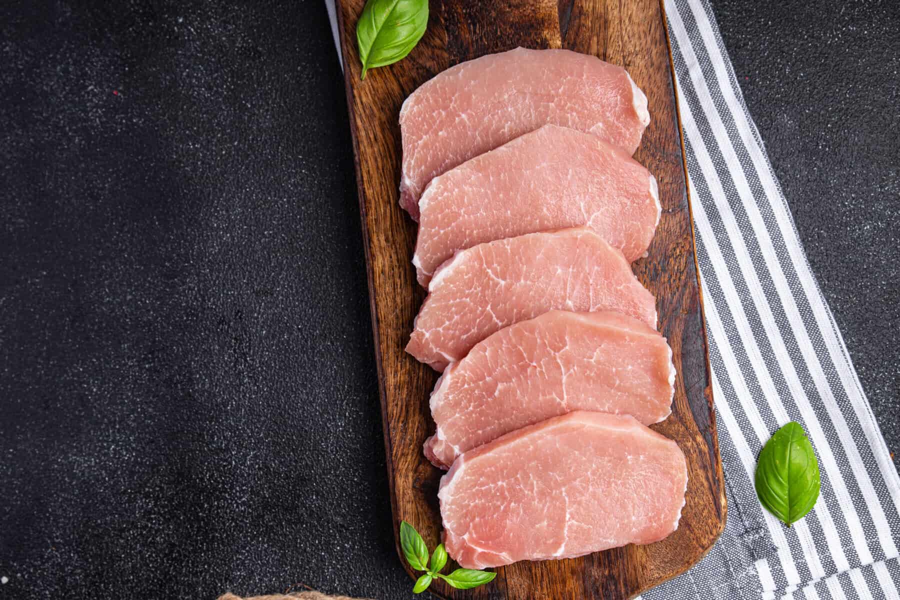 Schweinerückensteak auf Holzplatte